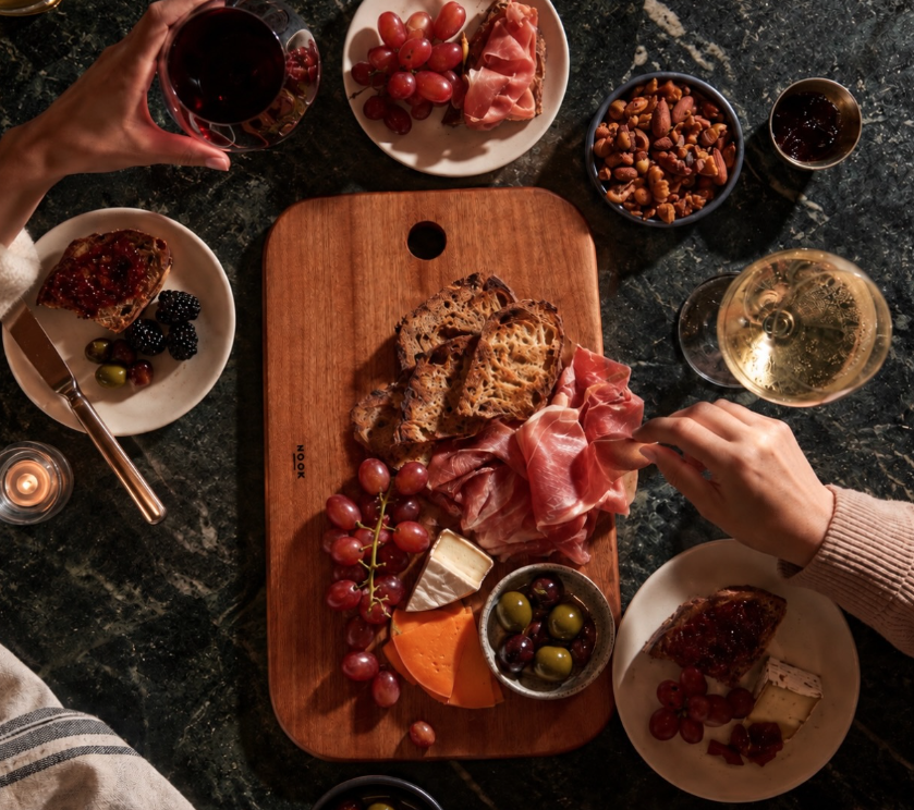 NOOK sharing board with charcuterie cheese grapes and wine